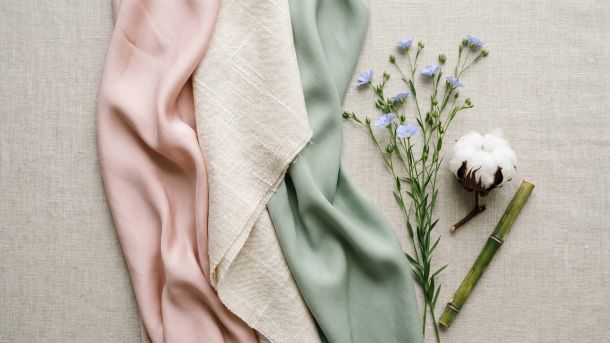 Silk, cotton, and bamboo fabric swatches arranged in a feminine flat-lay representing the best fabrics for women's intimate comfort