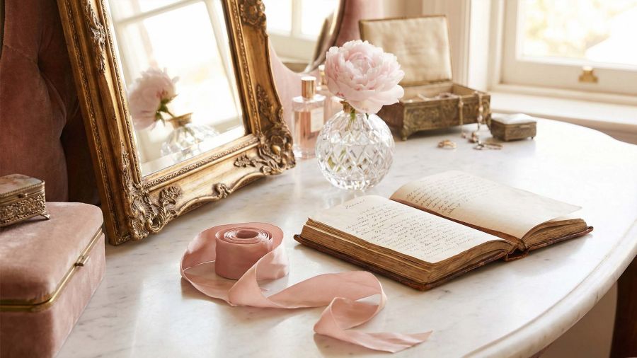 A sophisticated feminine vanity featuring a gold mirror and journal, representing the history of women's private education and health.