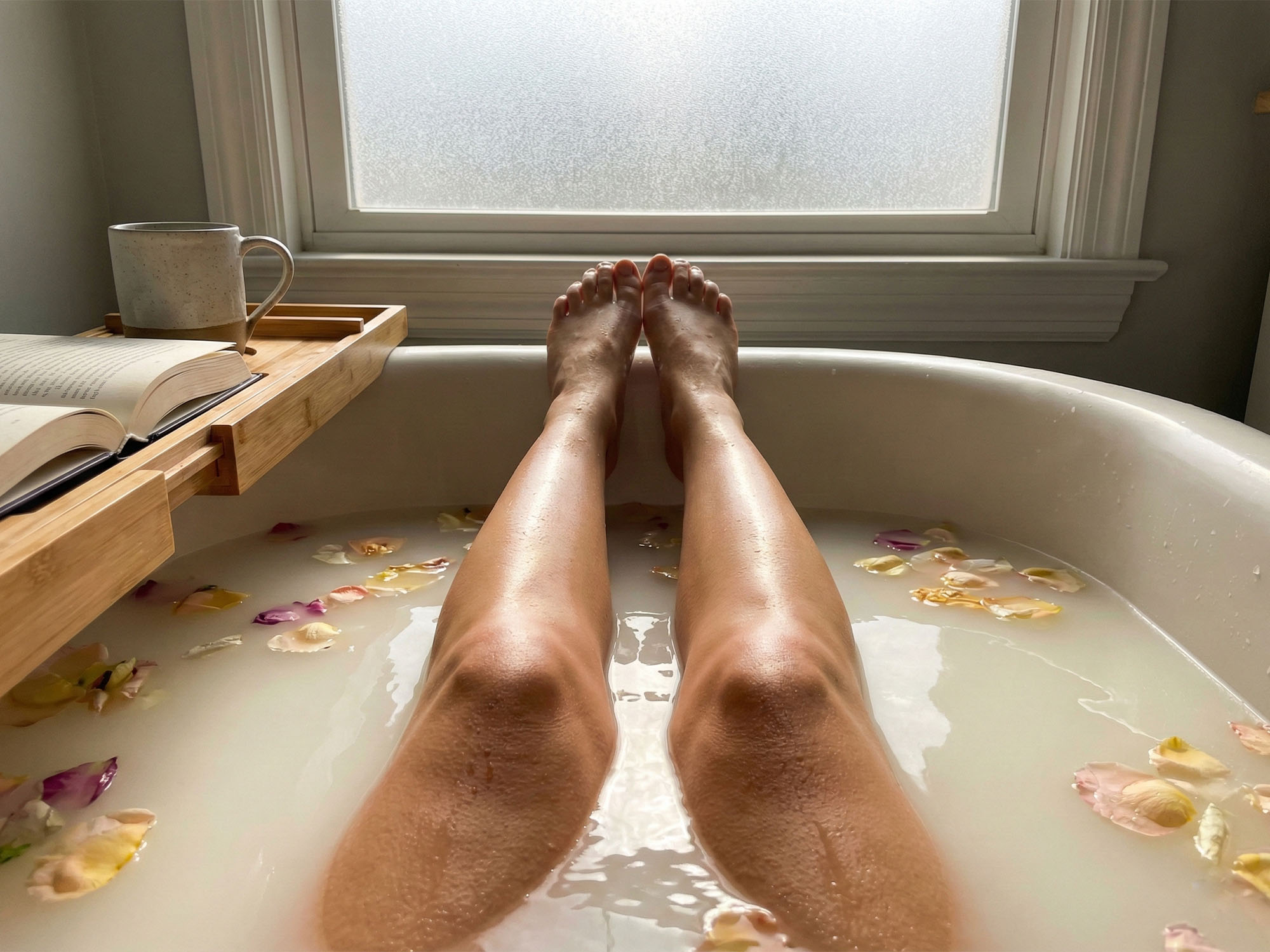 Close up of a woman's legs bathing with healthy glowing skin.