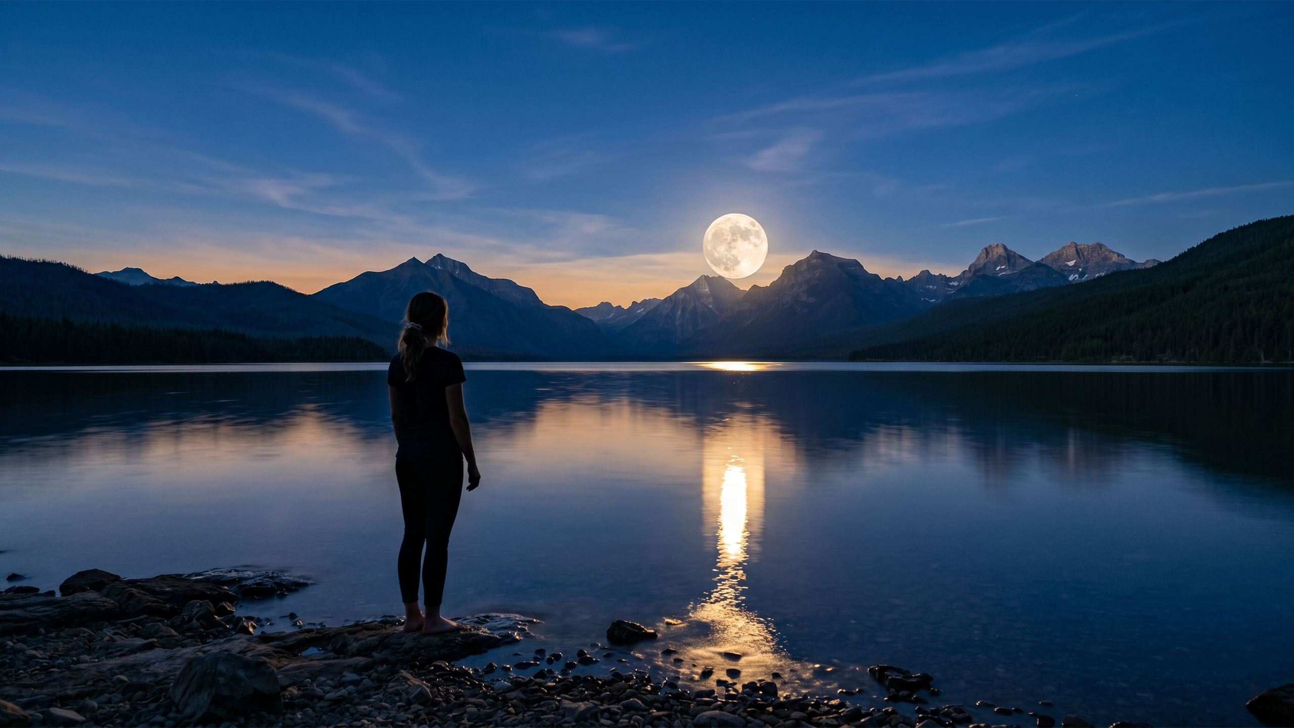 Full moon rising over calm ocean water at blue hour, with the silhouette of a woman standing at the shoreline looking up — symbolizing the ancient connection between the lunar cycle and the menstrual cycle