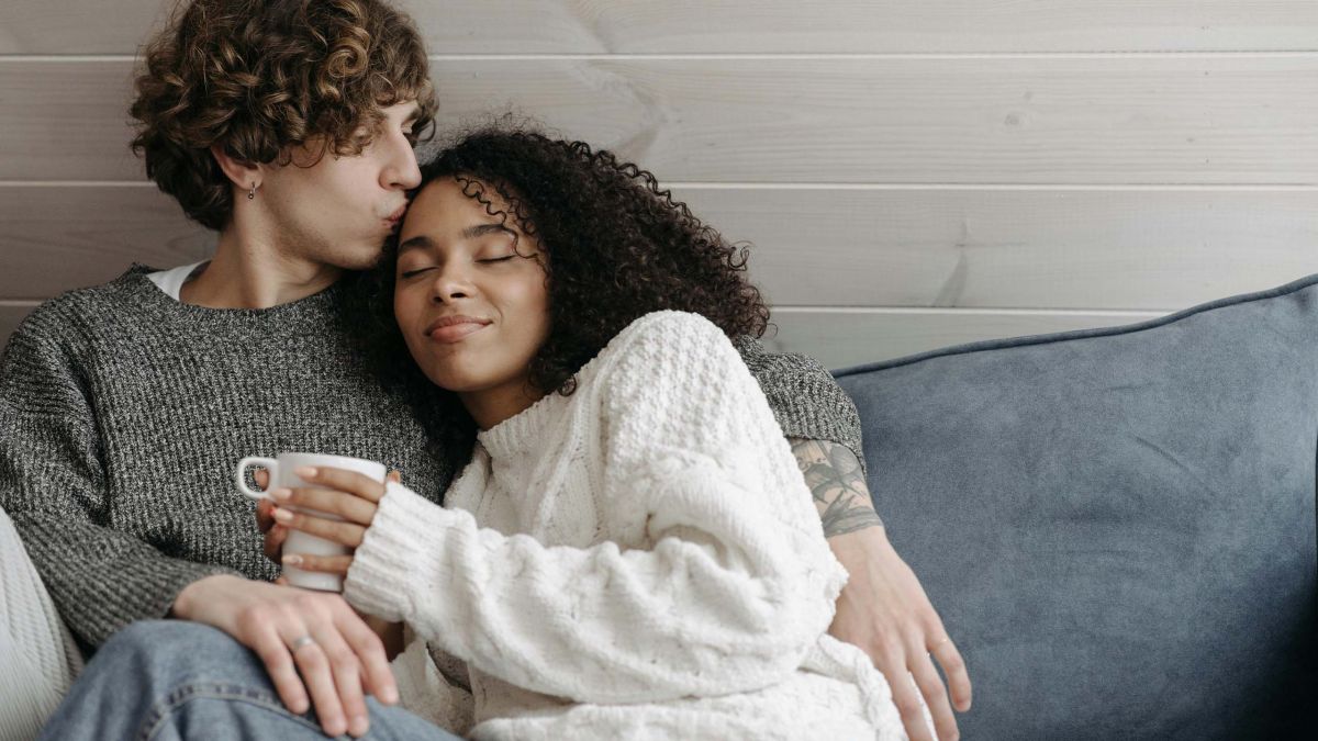 Couple sitting on a sofa having a calm, supportive conversation