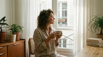 Une femme pratiquant une respiration consciente dans une pièce lumineuse et paisible pour réduire le stress.