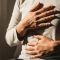 Hands gently resting on chest and abdomen, seated in natural light