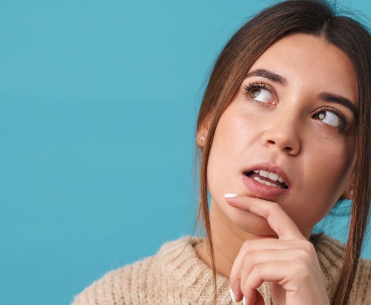 A woman thinking about the most common questions Gynecologists Hear Most Often.