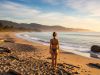 Une plage naturiste paisible où les voyageurs profitent du soleil en toute sérénité.